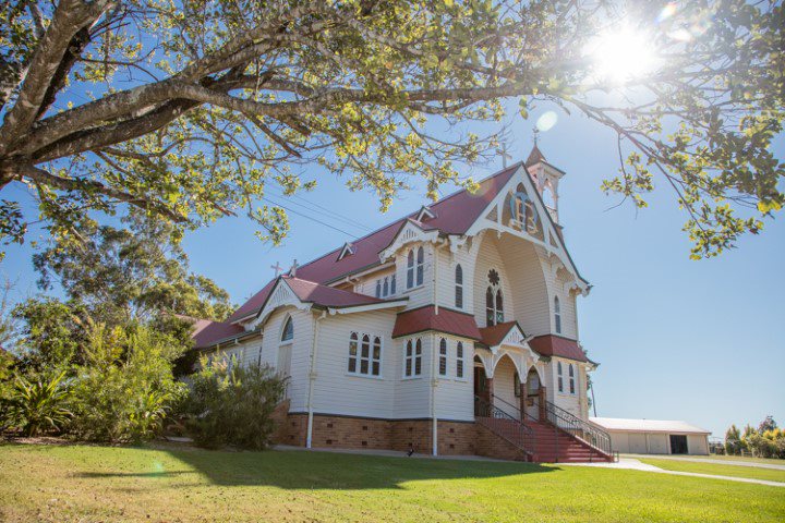 Exterior of St Mary’s church building set within landscaped grounds, highlighting heritage architecture, Catholic identity and connection to the school community